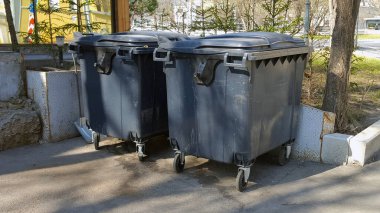 Şehir caddesinde iki siyah çöp tenekesi