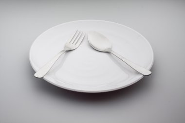 gümüş çatal ve kaşık gri arka plan üzerinde izole levha