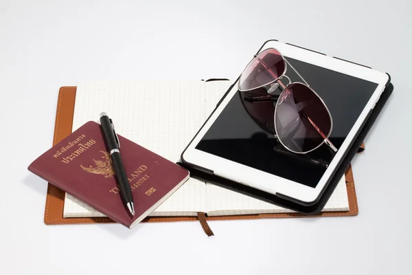 Comprimido com passaporte notebook e caneta — Fotografia de Stock