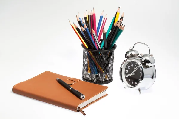 Notizbuch mit Stiftbox und Uhr auf isoliertem Hintergrund. — Stockfoto