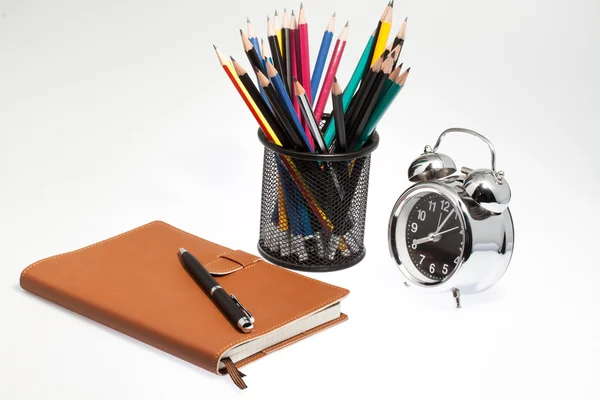Portátil con caja de lápiz y reloj —  Fotos de Stock