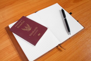 pasaport ve kalemi ile ahşap arka plan açık defter
