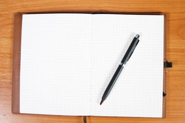 Öppna anteckningsboken med pass och penna över trä bakgrund — Stockfoto