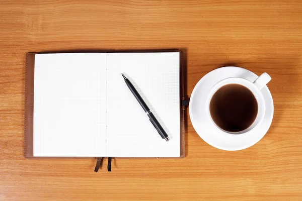 Open a blank white notebook, pen and cup of coffee on the desk Stock Photo