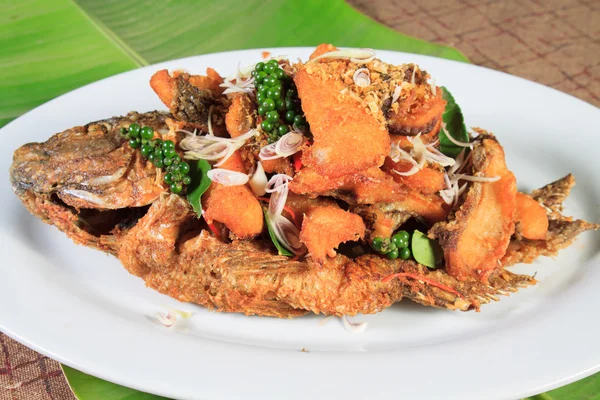 Estilo de comida tailandesa: peixe frito coberto com molho de pimenta — Fotografia de Stock