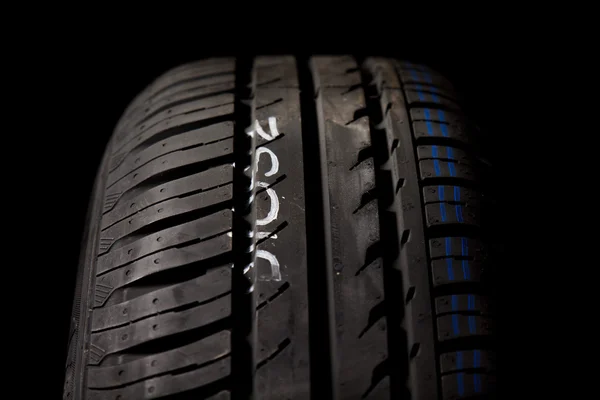 Neumáticos del coche primer plano sobre fondo negro — Foto de Stock