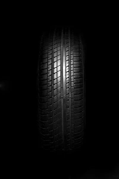 Neumáticos del coche primer plano sobre fondo negro — Foto de Stock