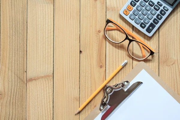 Clip board with calculator on wood background — Stock Photo, Image