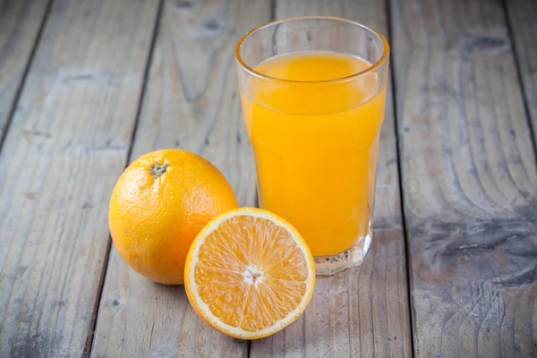 Стакан апельсинового сока с апельсином — стоковое фото