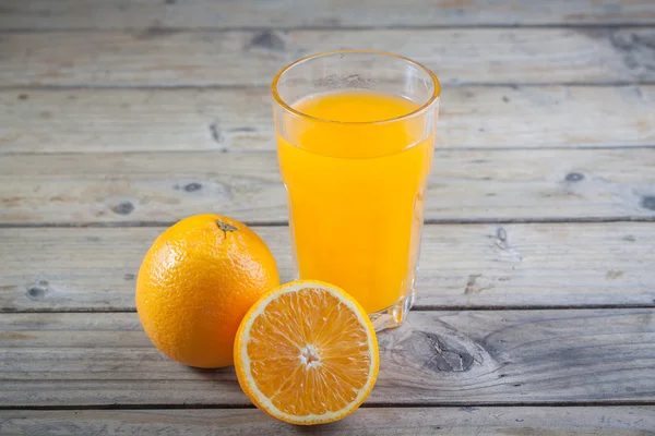 Закрытый апельсиновый сок на деревянном фоне — стоковое фото