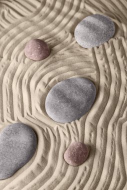 Kumda pürüzsüz çizgiler ve kaya bahçesindeki yuvarlak taşlar, rahatlama ve ruhsal uyum için. Meditasyon, rahatlama, denge ve maneviyat uyumu ve gevşeme Zen bahçesi