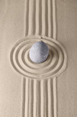 Gevşemek ve ruhsal uyum sağlamak için kayalık bahçesindeki kum ve yuvarlak taşlar üzerinde daireler. Meditasyon, rahatlama, denge ve maneviyat uyumu ve gevşeme Zen bahçesi