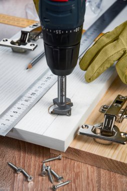 Çizgili tahtaya mobilya menteşeleri, aletler ve aksesuarlar yerleştirilmeli. Evde küçük marangozluk işleri, ev sahibi konsepti, evin kendi kendini tamir etmesi.