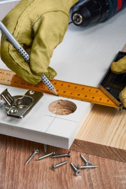 Çizgili tahtaya mobilya menteşeleri, aletler ve aksesuarlar yerleştirilmeli. Evde küçük marangozluk işleri, ev sahibi konsepti, evin kendi kendini tamir etmesi.