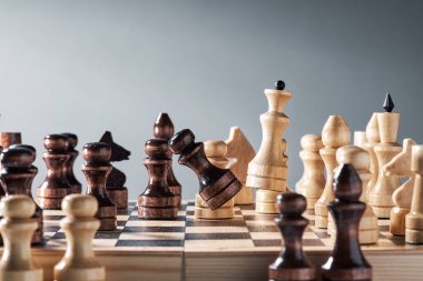 Satranç tahtasındaki tahta taşlar, beyaz vezir siyah piyonu yener, strateji, planlama ve karar verme kavramı. Başarı için liderlik ve takım çalışması kavramı.