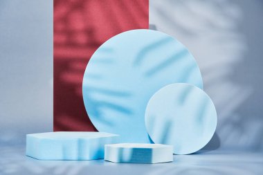 Geometric shapes on a blue background, empty podiums for the presentation of various products, abstract geometric background with a pedestal, space for text