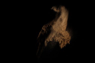 Kumsal patlaması siyah arka planda izole edildi. Soyut kum bulutu.