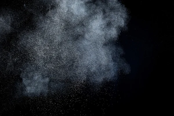 Siyah arkaplanda soyut beyaz toz patlaması