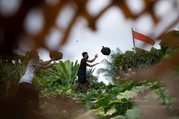 BALI, INDONESIA-SEPT 6 2020: Çok sayıda insan zarar görmüş bambu ön planı ile plastik atıkları temizlemek için birlikte çalışıyordu