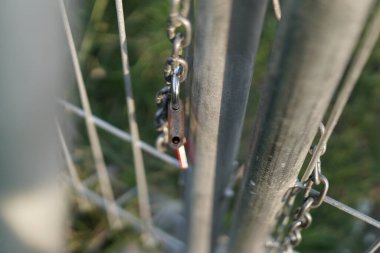 Demir kapıyı bağlayan zincirden serbest bırakılan kilit. Özgürlüğün işareti. Fotoğraf, Bokeh önplanıyla çekilmek.