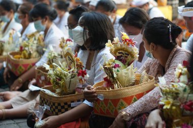 BALI, İNDONEZYA-MAY 12 2021: Covid-19 salgını zamanında Balili Hindu cemaatinin yaşamı. Dini faaliyetler, tıbbi maske takmak gibi sağlık protokollerini uygular