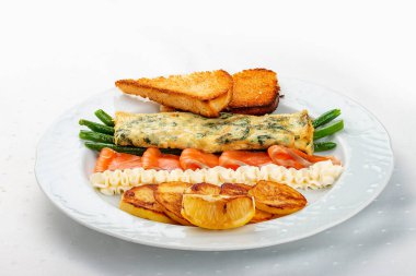 Kahvaltıda. Somon ve kuşkonmazlı omlet, fırında patates ve kızarmış ekmek.