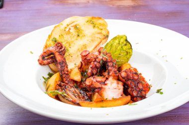 İtalyan usulü kızarmış ahtapot, domates ve patates.