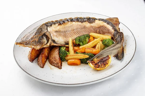 Sturgeon baked with potatoes and steamed vegetables