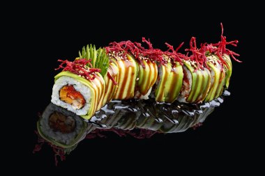 Siyah parlak bir arkaplanda yansıması olan Yeşil Ejder 'i yuvarla. İçi yılan balığı, tobiko, avokado, salatalık, omlet dolu.