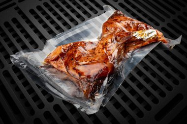 Süpürgeyle doldurulmuş ızgara et, koyu bir arka planda, tavuk butları. Yemek hazır..