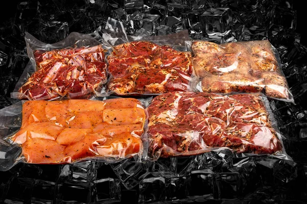 Különböző Vákuumcsomagolt Húsok Készlete Sötét Jégen Háttérben Félig Hántolt — Stock Fotó