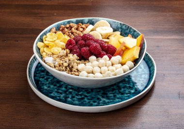 Muzlu müsli, fındıklı, şeftalili ve ahududulu. Ahşap bir arka planda. Kahvaltı.