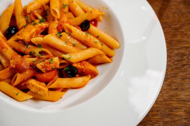 Domatesli spagetti makarna ve ahşap masa üzerinde maydanoz. Domates soslu makarna, taze fesleğen ve kızarmış domates.