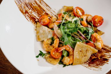 Karides, domates ve ahşap arka planda karışık sebzeli taze salata tabağı. Sağlıklı yemek. Sağlıklı salata tabağı. Taze deniz ürünleri tarifi. Izgara karides ve taze sebze salatası.