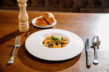 Karides, domates ve ahşap arka planda karışık sebzeli taze salata tabağı. Sağlıklı yemek. Sağlıklı salata tabağı. Taze deniz ürünleri tarifi. Izgara karides ve taze sebze salatası.