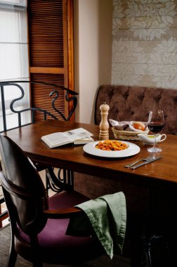 Domatesli spagetti makarna ve ahşap masa üzerinde maydanoz. Domates soslu makarna, taze fesleğen ve kızarmış domates.