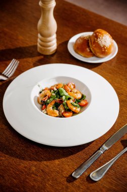 Karides, domates ve ahşap arka planda karışık sebzeli taze salata tabağı. Sağlıklı yemek. Sağlıklı salata tabağı. Taze deniz ürünleri tarifi. Izgara karides ve taze sebze salatası.