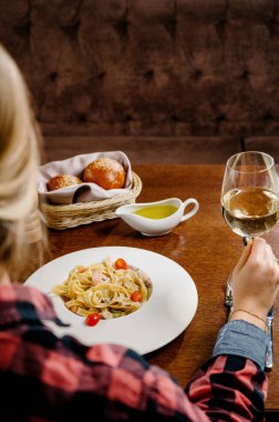 Masada lezzetli Alfredo usulü tavuk tabağı. Tavuklu makarna, parmesan peyniri ve ahşap arka planda maydanoz. İtalyan mutfağı.