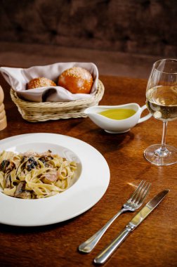 Mantarlı kremalı ıspanaklı makarna, mantarlı makarna, kremalı sos ve ahşap arka planda maydanoz.