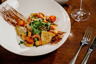 Karides, domates ve ahşap arka planda karışık sebzeli taze salata tabağı. Sağlıklı yemek. Sağlıklı salata tabağı. Taze deniz ürünleri tarifi. Izgara karides ve taze sebze salatası.