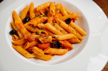 Domatesli spagetti makarna ve ahşap masa üzerinde maydanoz. Domates soslu makarna, taze fesleğen ve kızarmış domates.