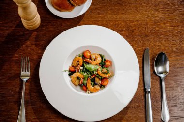 Karides, domates ve ahşap arka planda karışık sebzeli taze salata tabağı. Sağlıklı yiyecekler. Temiz yemek..