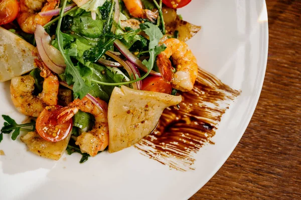 Placa de ensalada fresca con camarones, tomate y verduras mixtas sobre fondo de madera de cerca. Comida saludable. Comer limpio. Imagen De Stock