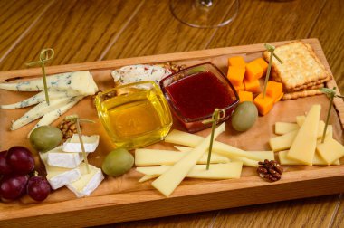 Tahta kesim tahtasında çeşitli peynir türleri, üst görünüm.