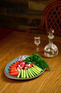 Tahta bir masada taze kesilmiş sebzeler. Taze domates, salatalık, turp ve ottan oluşan aperatif. Sağlıklı beslenme, diyet, vejetaryenlik kavramı..