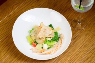 Kavurmalı Sezar salatası, bıldırcın yumurtası, kiraz domatesleri ve ahşap masada ızgara tavuk. Tavuk, fındık, yumurta ve sebzeli lezzetli salata..