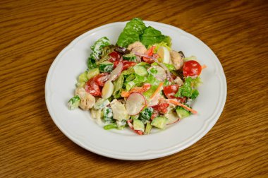 Sebzeli vejetaryen salata, domates, biber ve soğanlı ahşap masa. Taze olgun sebzeli sağlıklı salata.