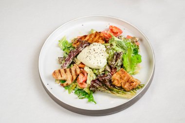 Kavurmalı Sezar salatası, bıldırcın yumurtası, kiraz domatesleri ve beyaz masada ızgara tavuk. Tavuk, fındık, yumurta ve sebzeli lezzetli salata..