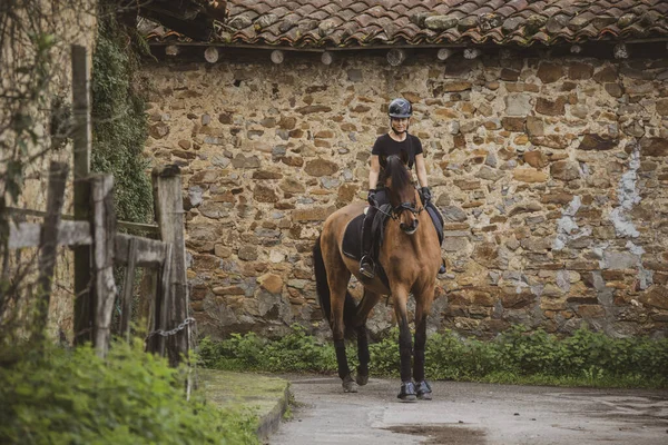 Female Rider Dressed Black Her Brown Horse Riding Village Stone — Stock Photo, Image