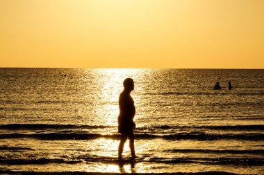 Aktif yaşlı yetişkinler, Kıbrıs 'ta huzurlu bir altın gün doğumu sırasında Akdeniz kıyısında sakin bir sabahın keyfini çıkarıyorlar..